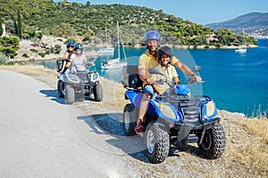 Family riding quad bike. Cute boy and his father on quadricycle. Motor cross sports on Greece island. Family summer