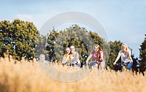 Family riding their bikes shot above a grain field