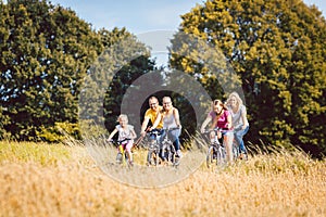 Family riding their bikes shot above a grain field