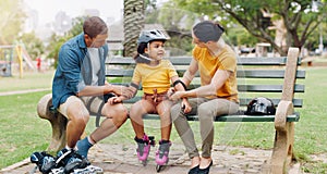 Family, rollerskate and interracial parents help kid with safety pads teaching her skating at the park and bonding