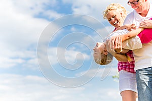 Family romping on field photo