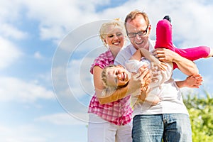 Family romping on field with parents photo