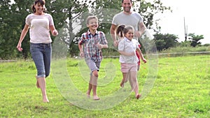 Family Running Across Field In Slow Motion