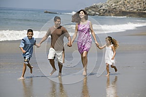 Family Running Along Beach