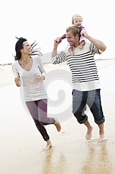 Family Running Along Beach Together