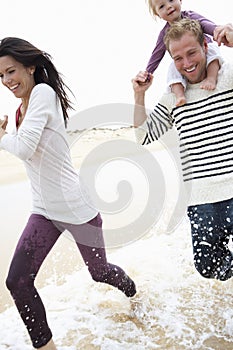 Family Running Along Beach Together