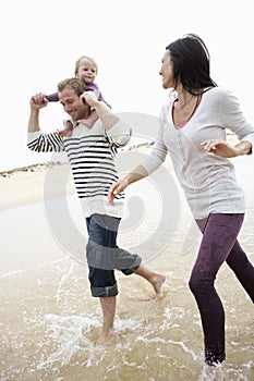 Family Running Along Beach Together