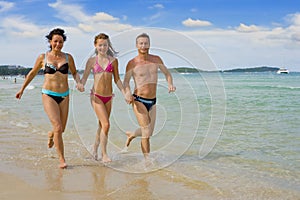 Family running at the beach