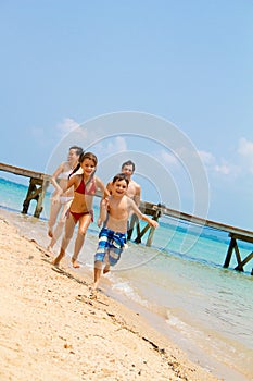 Family running on the beach