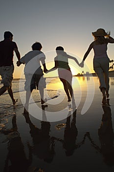Family Running On The Beach