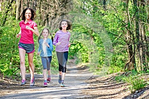 Family running, happy active mother and kids jogging outdoors, run with children in forest, healthy family sport