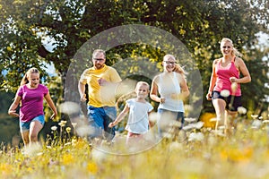 Family running on a meadow for sport