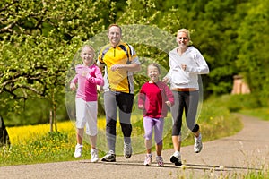 Family running in the meadow for sport photo