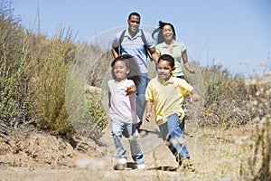 Family running on path smiling