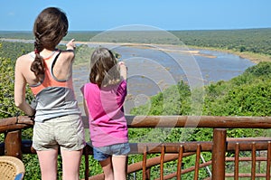 Family safari vacation in South Africa, mother and daughter looking at beautiful african river view, tourists travel Kruger park