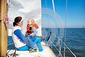 Family sailing. Mother and child on sea sail yacht.