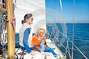 Family sailing. Mother and child on sea sail yacht.