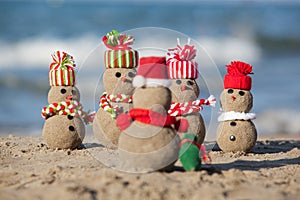 Family of sandy Snowmen at tropical beach.