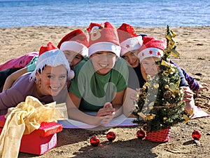 Family with Santa Claus hat on beach