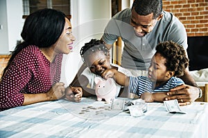 Family saving money in piggy bank photo