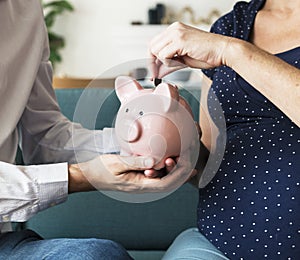 Family saving money in piggy bank