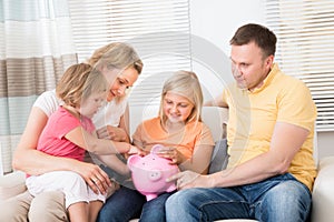 Family saving money in piggybank