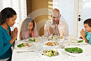 Family Saying Grace Before Meal At Home photo