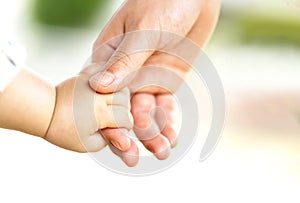 Family scene , close up parent and baby holding hands together