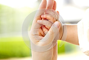 Family scene , close up parent and baby holding hands together