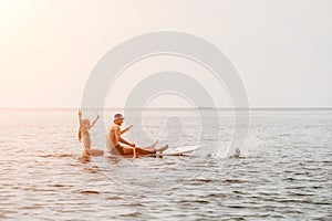 Family sea sup. Young happy father with his son and daughter Floating on a SUP board, paddling in blue sea water. summer