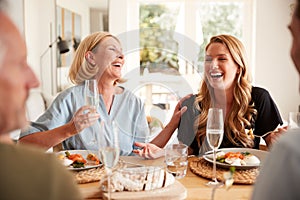 Family With Senior Parents And Adult Offspring Eating Brunch Around Table At Home Together