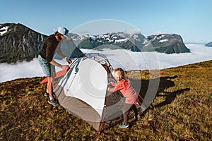 Family setting up tent camping gear in mountains father and child hiking together active travel vacations outdoor in Norway