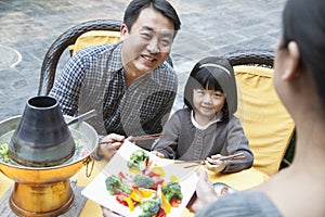 Family sharing and eating Chinese food outside