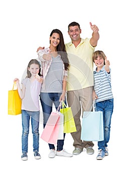 Family with shopping bags gesturing thumbs up