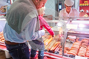 Family shopping for fresh meat in a supermarket