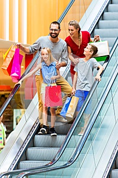 Family in shopping mall on escalators