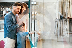 Family In Shopping Mall. People Looking Through Window