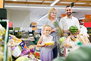 family shopping various fresh fruits in supermarket