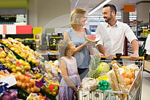 Family shopping various fresh fruits in supermarket