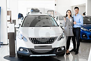 Family Showing Car Key Standing In Dealership photo