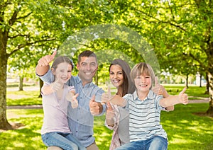 Family showing thumbs up in park