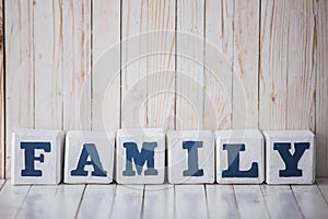 FAMILY sign made of wooden blocks on wooden background