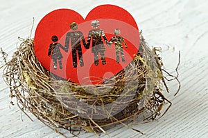 Family silhouette cut out in paper heart in a nest - Concept of love and family