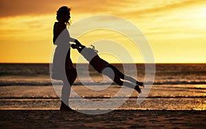 Family, silhouette and sunset at beach with mother swinging child against yellow sky with love, care and support on