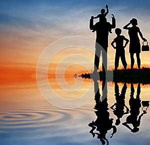 Family silhouette on sunset sky.