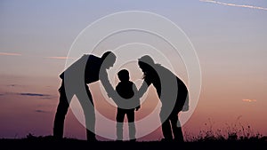 Family silhouettes put hands together, perfect team and support, sunset deal