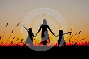 Family silhouettes at sunset mom daughters photo