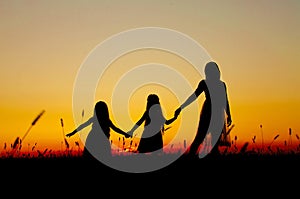 Family silhouettes at sunset mom daughters photo