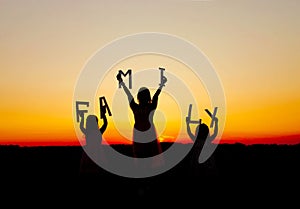 Family silhouettes at sunset mom daughters photo