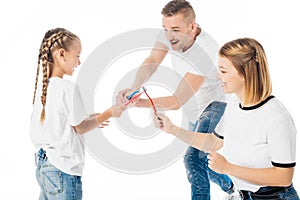 family in similar clothing playing with toothbrushes